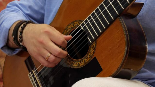 close up of a man playing acoustic guitar