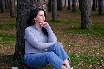 A woman lying on a tree and looking around