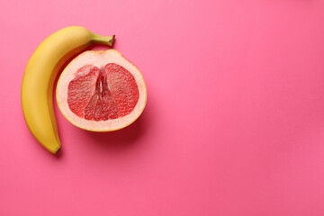 Banana and half of grapefruit on pink background, flat lay with space for text. Sex concept
