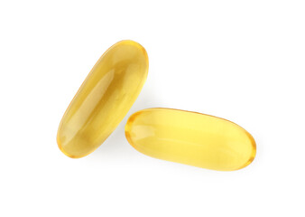 Two yellow vitamin capsules isolated on white, top view