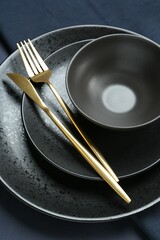Stylish ceramic plates, bowl and cutlery on table