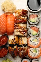 Set of delicious sushi rolls on board, top view