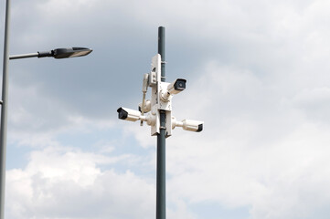Urban Surveillance Cameras Against Cloudy Sky