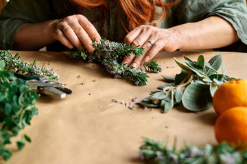 Herbal medicine. Woman's hands preparing blooming rosemary and others eco friendly medicinal herbs...