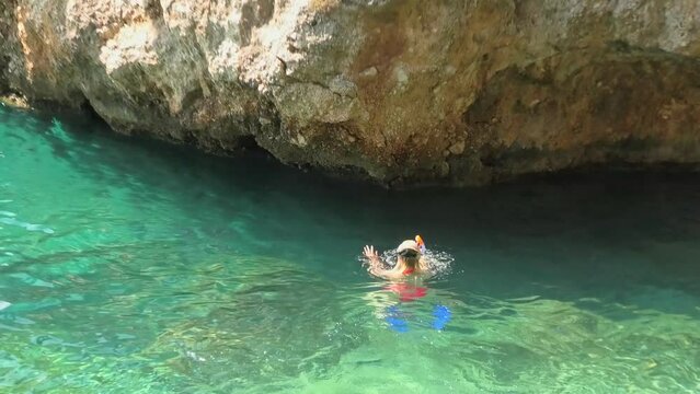 Close up of a bikini girl swimming with mask in Punta Rata beach of Croatia. Famous Brela stone or Kamen Brela. Swimming in Croatian Adriatic Sea in the Split-Dalmatia County of Croatia.