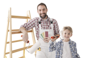 Father and son painting walls and posing