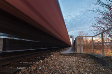Freight train, cargo ride on bridge at sunset. Shipment, transportation concept, long exposure