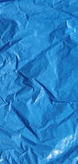 Crumpled texture of a blue cellophane bag. Blue pixelated texture background. Texture of a garbage bag. Polyethylene blue background. Interior design texture.