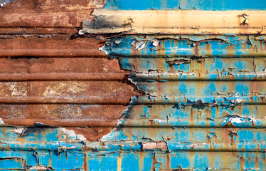 pattern rusty metal surface with remnants of blue and yellow paint paint