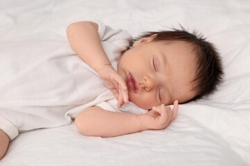Cute newborn baby sleeping on white bed