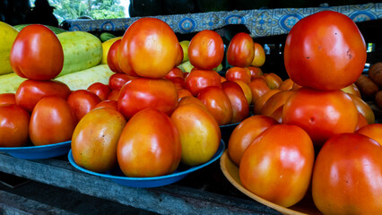 Plates of delicious, juicy, red tomatoes neatly stacked at fruit and vegetable market in Dili, Timor-Leste, Southeast Asia