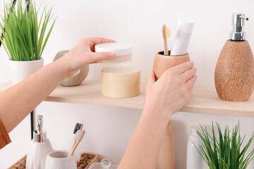 Obraz na płótnie Canvas Bath accessories. Woman organizing personal care products indoors, closeup