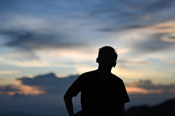 Silhouette of a man standing alone on the mountain, Solo travel concept
