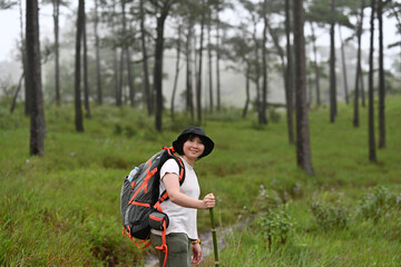 Fototapeta premium Portrait of Asian female hiker turning to look at camera, Solo Travel and hiking concept