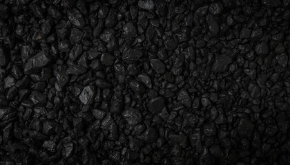 Fototapeta premium Close-up of textured black rocks or gravel, uniformly spread. Highlights natural patterns and shapes