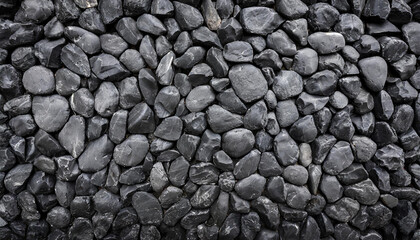 Close-up detailed of textured black rocks or gravel, uniformly spread. Highlights natural patterns and shapes