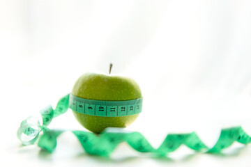 Close up fresh apple and tape measure.  Healthy snack for diet planning. White background.  Healthy Lifestyle Concept.