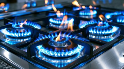 Close up of blue propane gas flames burning on a domestic kitchen stove top appliance