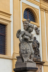 Fototapeta na wymiar Baroque statue before facade Loreta Monastery in Prague, Czech Republic
