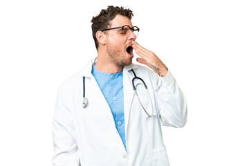 Brazilian doctor man over isolated chroma key background yawning and covering wide open mouth with...