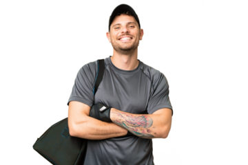 Young sport man with sport bag over isolated chroma key background keeping the arms crossed in frontal position