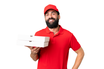 Pizza delivery man with work uniform picking up pizza boxes over isolated chroma key background posing with arms at hip and smiling
