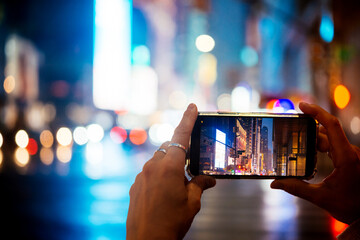 A person takes a mobile photo of evening Manhattan lights in New York City, United States. - 739206788