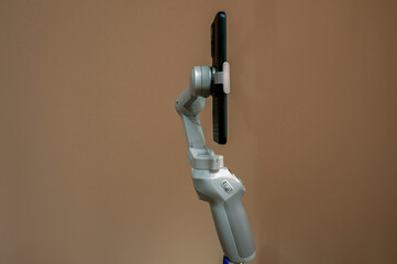 Steadicam stabilization for a mobile phone camera in a hand on a white isolation background. Stabilizer for a smartphone.