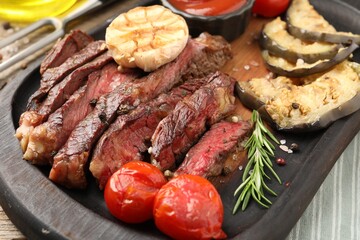 Delicious grilled beef steak with vegetables and spices on table, closeup