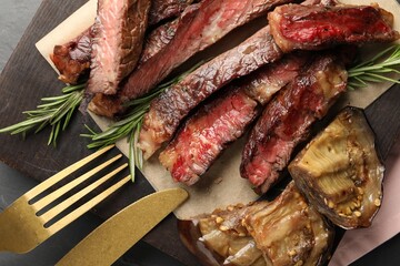 Delicious grilled beef with eggplant and rosemary served on table, top view