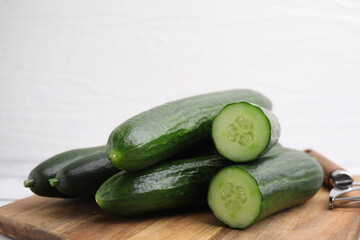 Many fresh cucumbers on wooden board, closeup