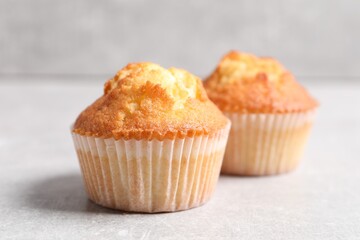 Tasty muffins on light grey table, closeup. Fresh pastry