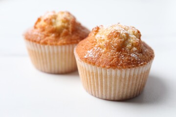 Delicious sweet muffins on white table, closeup