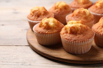 Delicious sweet muffins on wooden table, closeup. Space for text