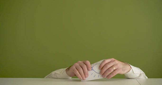 a man's hands find and present the note with the word Ideea