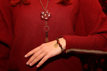 Jewelry made of natural stone red jasper on the background of a sweater.
