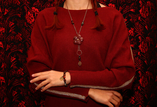 Jewelry made of natural stone red jasper on the background of a sweater.
