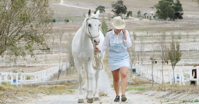 Happy woman, phone call and walking horse for communication or conversation in the countryside. Female person, farmer or cowgirl talking with mobile smartphone, animal or outdoor discussion in nature