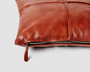 Closeup of handcrafted terracotta leather sofa pillow with side zipper © nazarovsergey