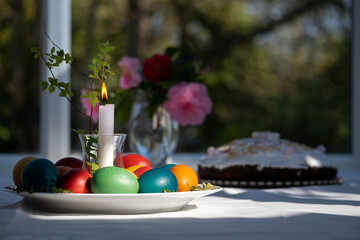 Elegant Spring Table Setting with Colorful Easter Eggs, Candle, and Dessert