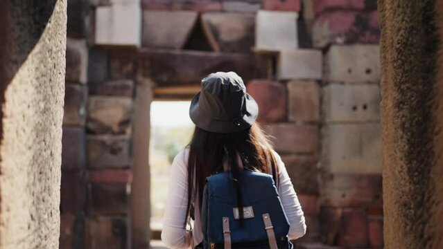 In the heart of the city, a young woman with a backpack looks into the distance, suggesting a moment of introspection or the beginning of a journey.