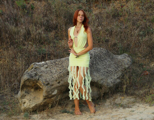 Selfie portraits of a red-haired woman in a yellow fantasy cocktail dress on the beach next to the...