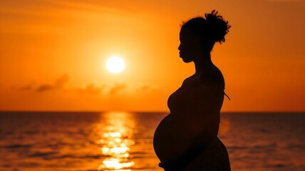 Fototapeta premium Golden Sunset Embrace: Pregnant Woman's Silhouette
