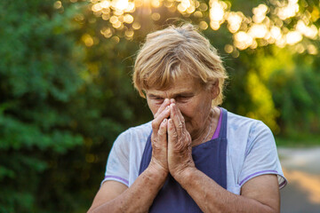 An elderly woman prays in the garden. selective focus.