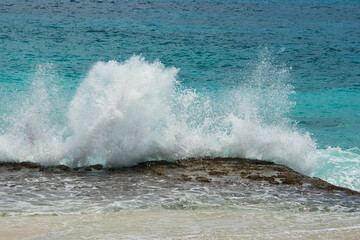 Breaking waves on the rocks near the shore, big splash, Mahe Seychelles