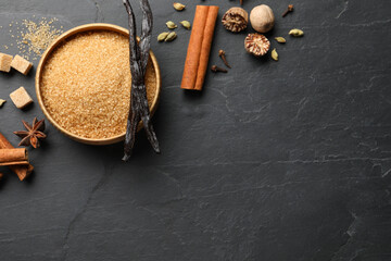 Different aromatic spices on dark textured table, flat lay. Space for text