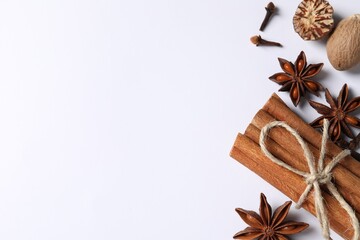 Different spices and nuts on white background, flat lay. Space for text