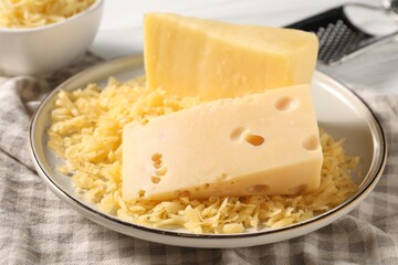 Grated and whole pieces of cheese on table, closeup