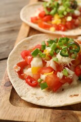 Delicious tacos with vegetables, green onion, lime and ketchup on wooden table, closeup
