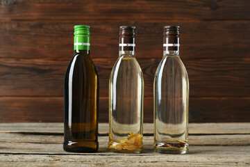 Vegetable fats. Different cooking oils in glass bottles on wooden table